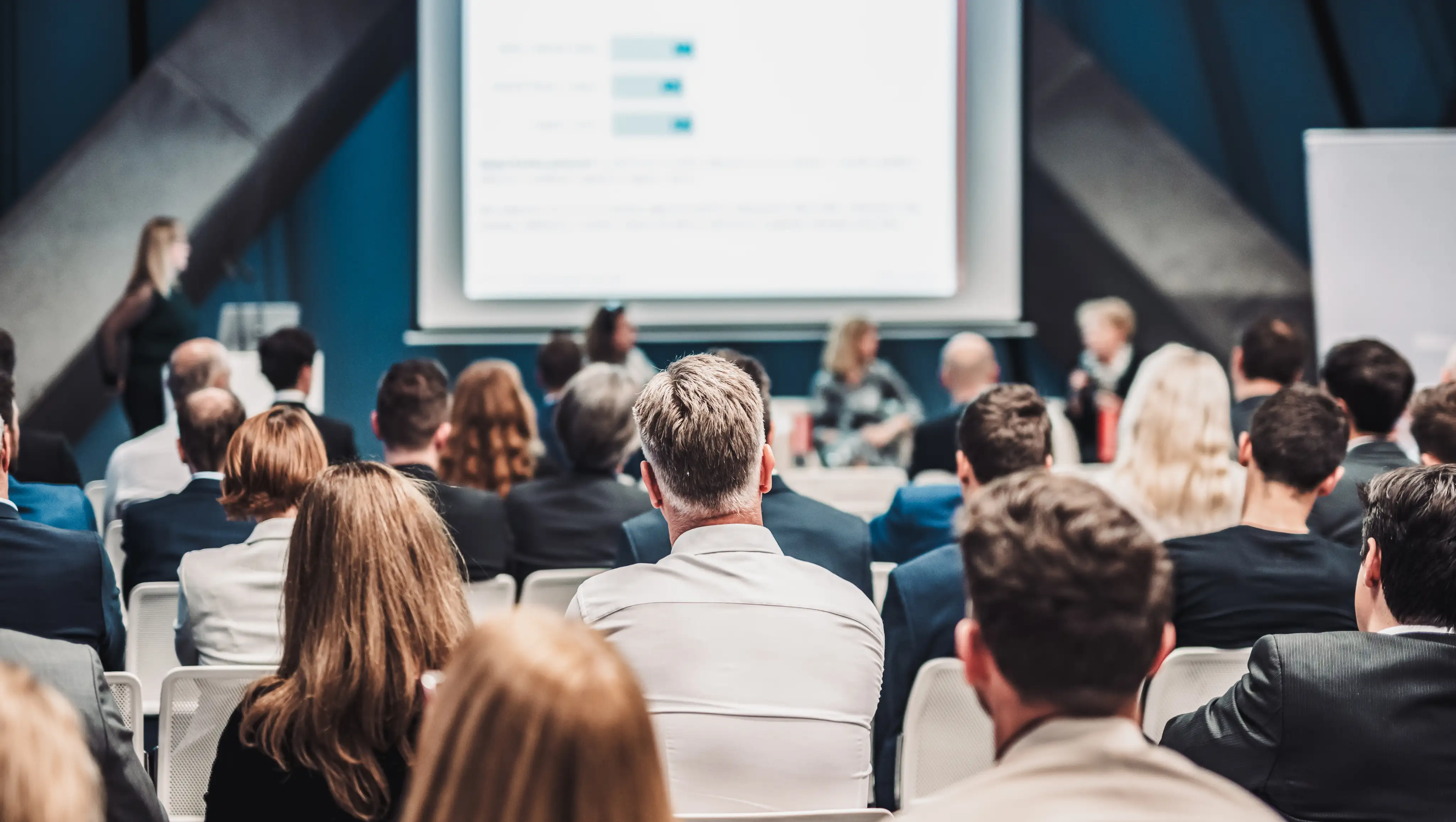 Participants réunis lors d’un événement public avec panel de discussion